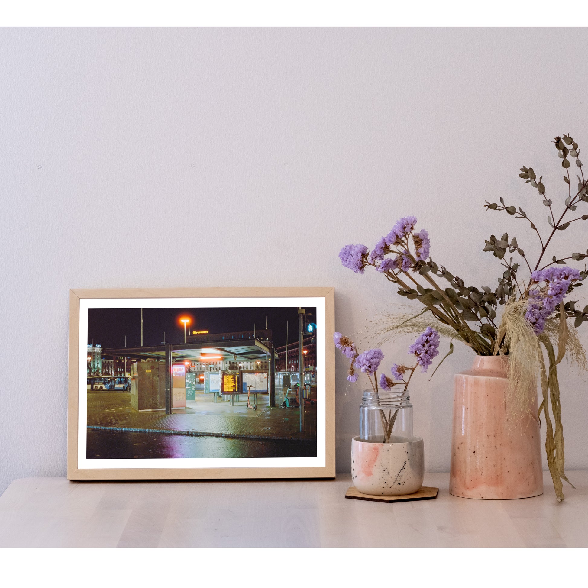Detail of the 21x30 size photo in a frame, next to a ceramic pot with flowers. It is larger than the pot, and half the height of most of the flowers. In width, it is two and a half pots next to each other.